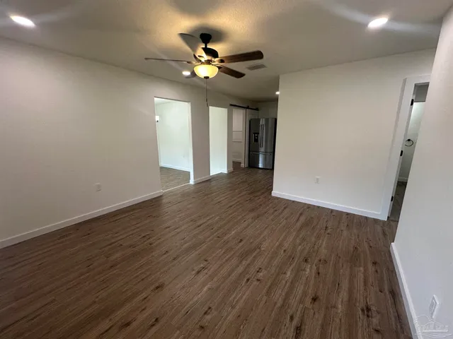 a view of an empty room with wooden floor