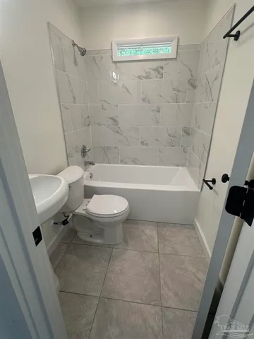 a white toilet sitting next to a bath tub a sink and a shower