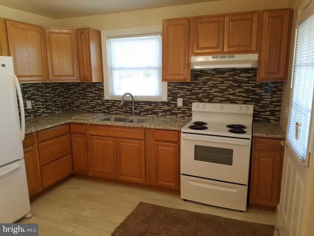 28234 Stanford Road Eden, MD 21822 - Photo 12 of 35 a kitchen with granite countertop white cabinets sink and white appliances