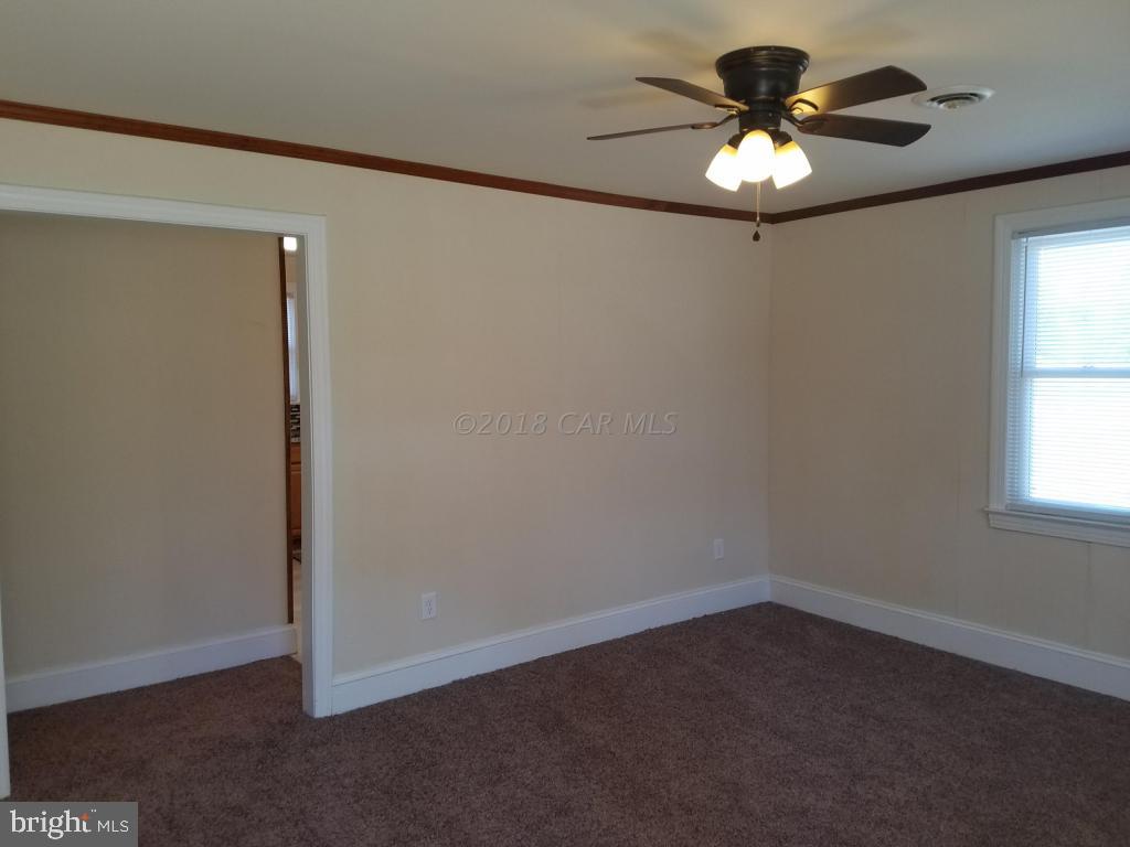 28234 Stanford Road Eden, MD 21822 - Photo 18 of 35 an empty room with a chandelier fan and windows
