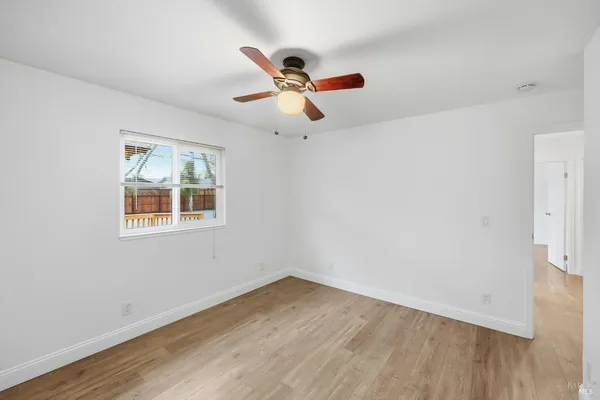an empty room with wooden floor and shelves