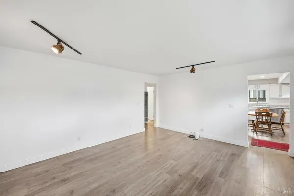 an empty room with wooden floor and window