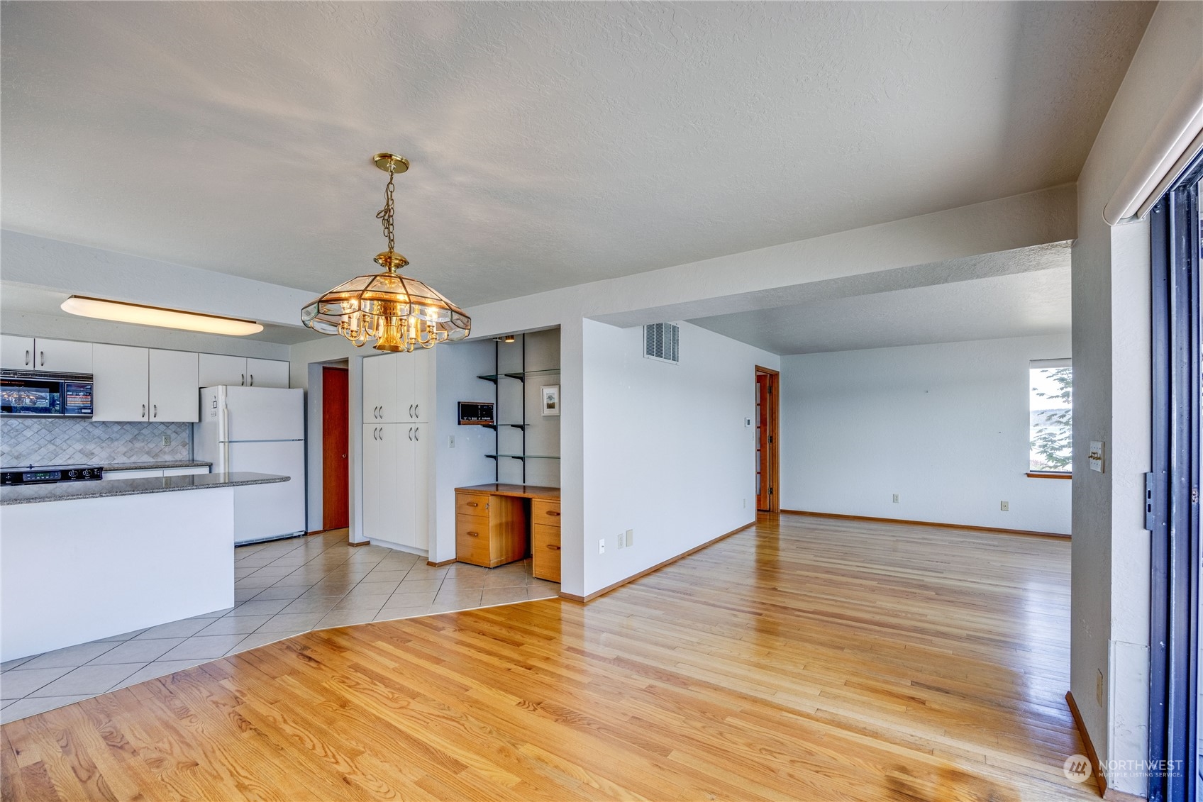 924 Shore Drive Bremerton, WA 98310 - Photo 15 of 36 a view of a kitchen with a sink wooden cabinets and a living room
