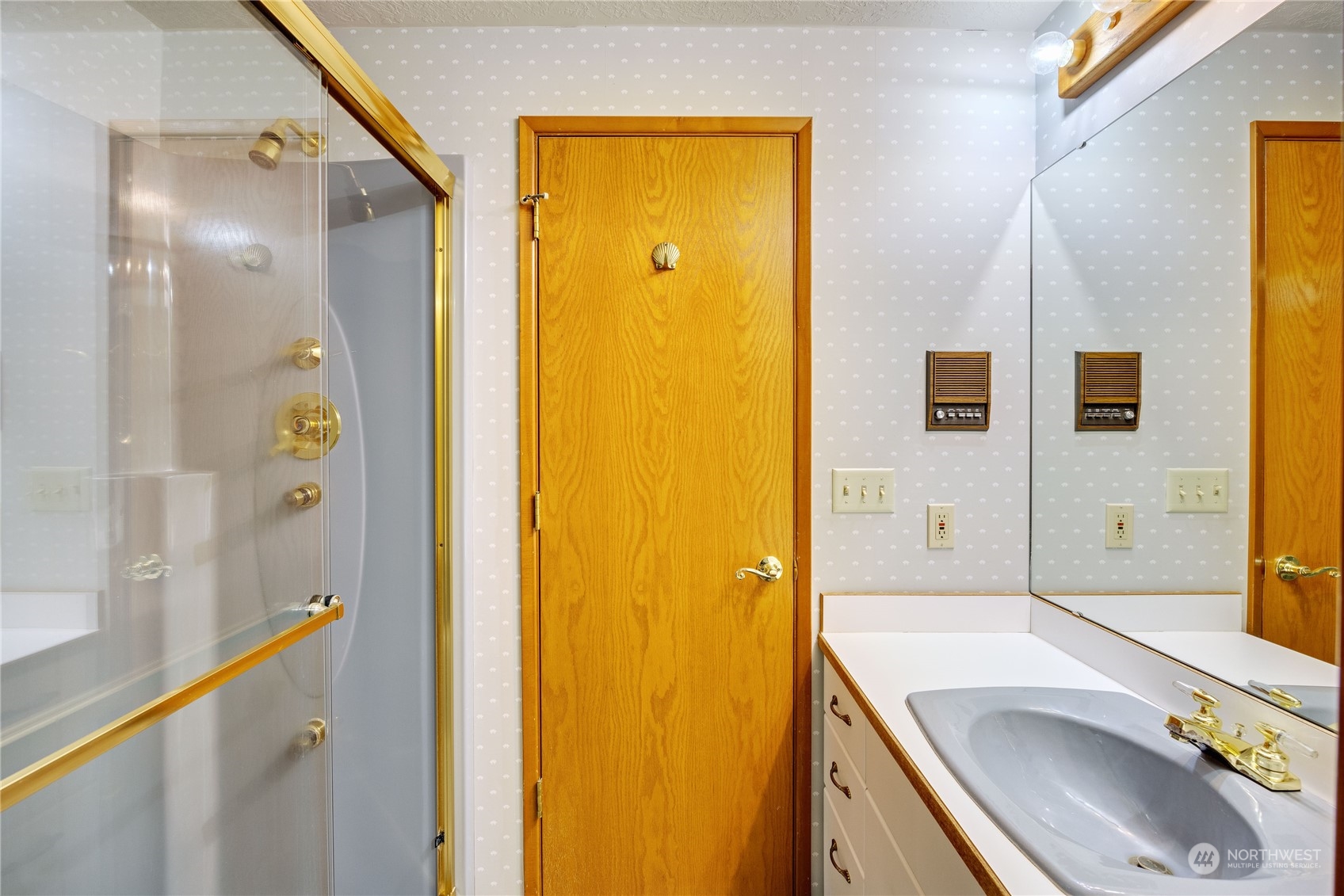 924 Shore Drive Bremerton, WA 98310 - Photo 22 of 36 a bathroom with a sink a mirror and a shower