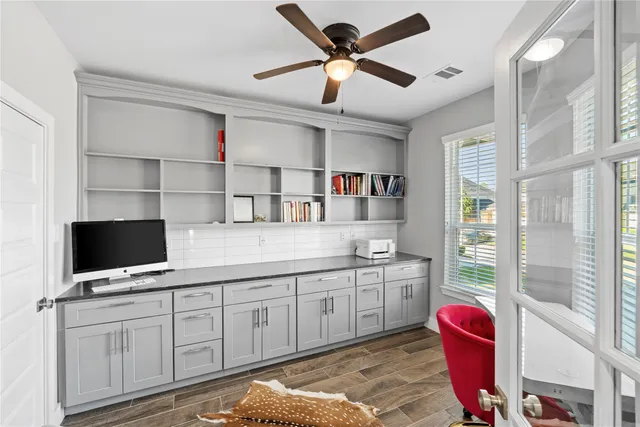 a kitchen with a stove cabinets and a flat screen tv