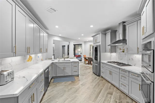 a large kitchen with stainless steel appliances lots of counter space sink and stove