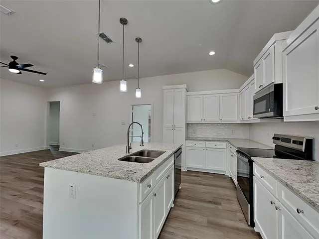 a kitchen with a sink stove and microwave