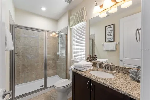 a bathroom with a granite countertop sink toilet and shower