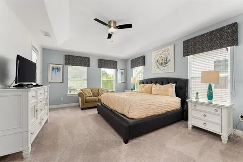 a spacious bedroom with a bed and a flat screen tv