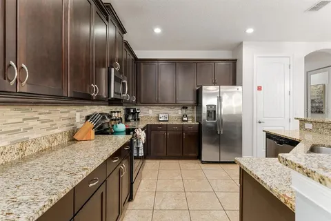 a kitchen with granite countertop stainless steel appliances and wooden cabinets