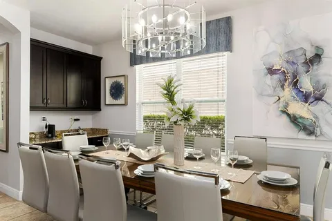 a view of a dining room with furniture a chandelier and large window