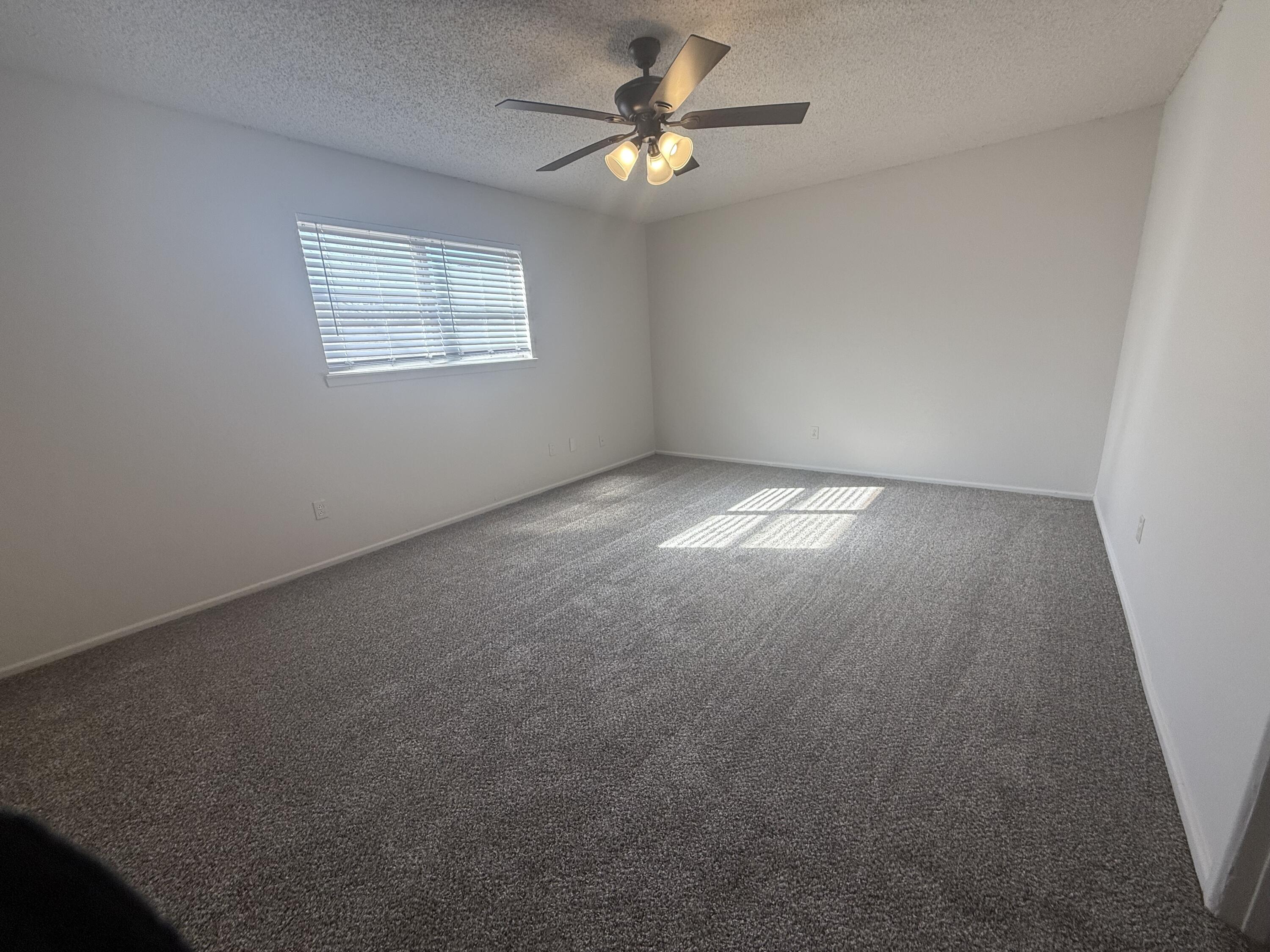 2317 15th Street Lubbock, TX 79401 - Photo 4 of 8 an empty room with windows and fan