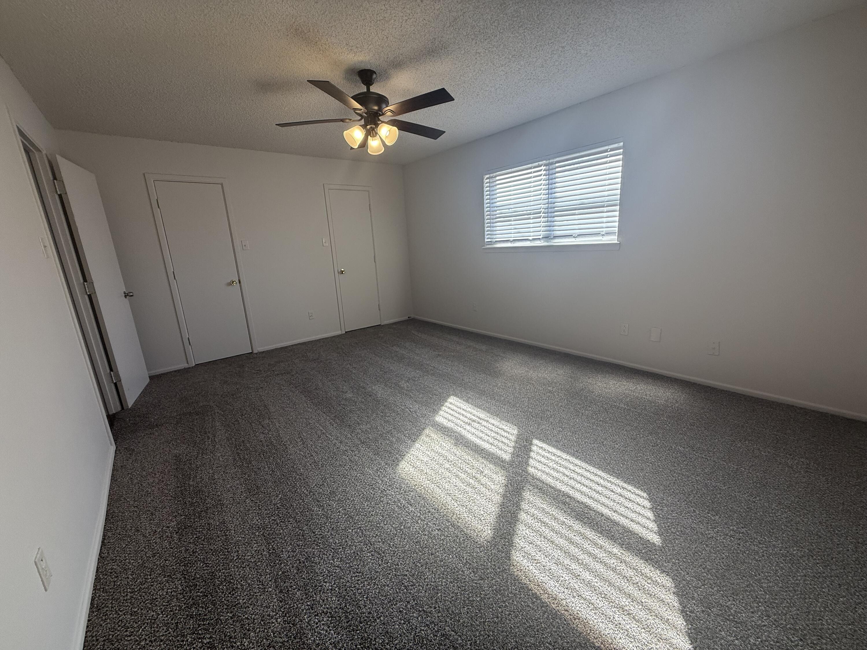2317 15th Street Lubbock, TX 79401 - Photo 5 of 8 an empty room with windows and chandelier fan