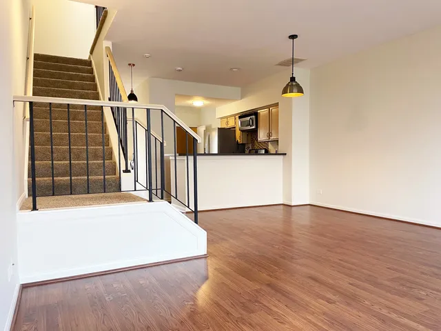 a view of empty room with wooden floor and windows