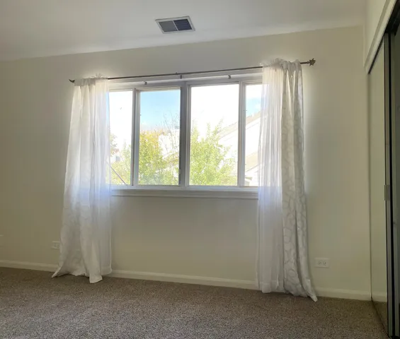 an empty room with a windows and closet