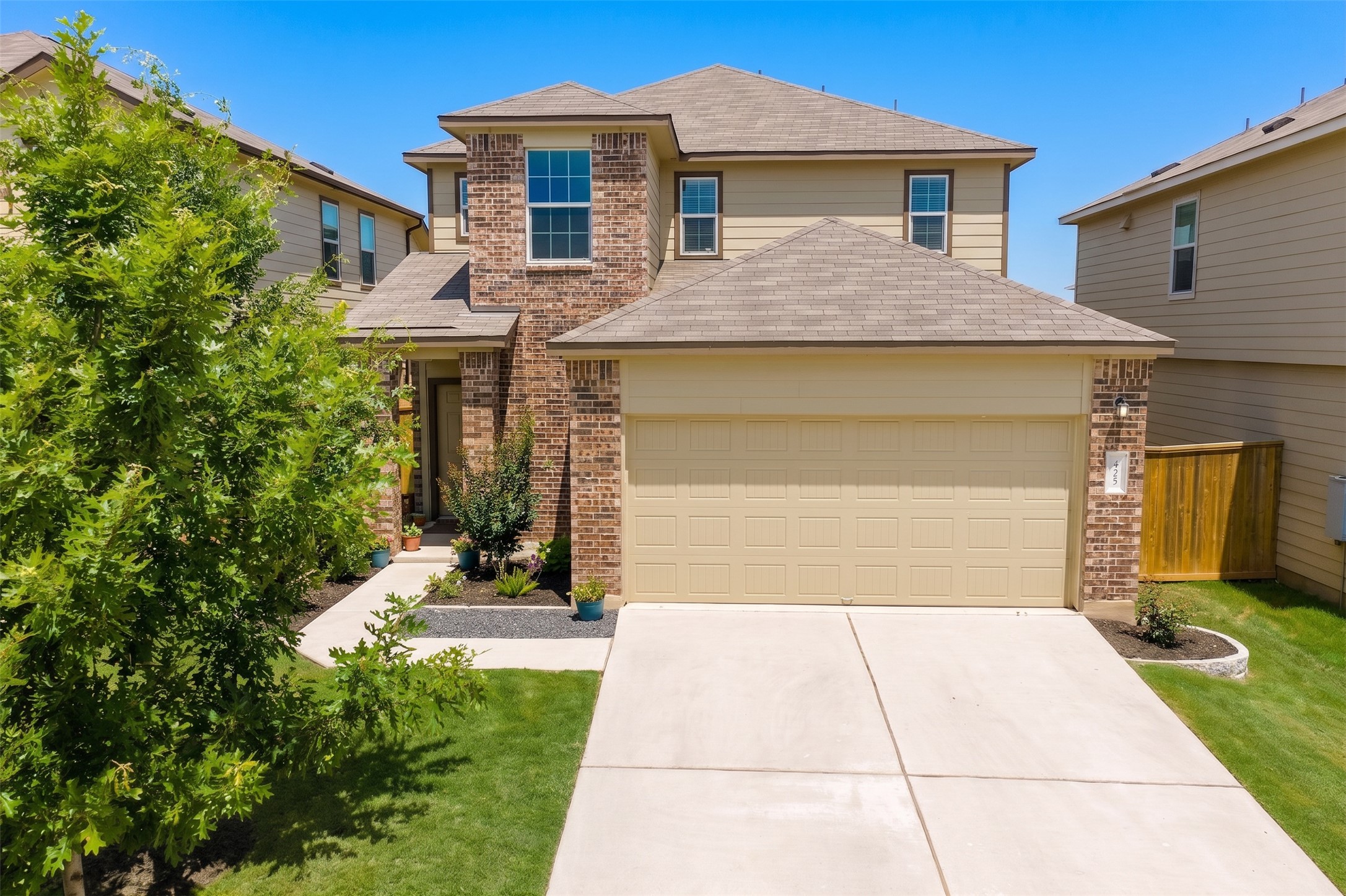 425 Perfect World Loop Jarrell, TX 76537 - Photo 2 of 29 Two-story residence featuring brick and siding exterior, a two-car garage, and a concrete driveway