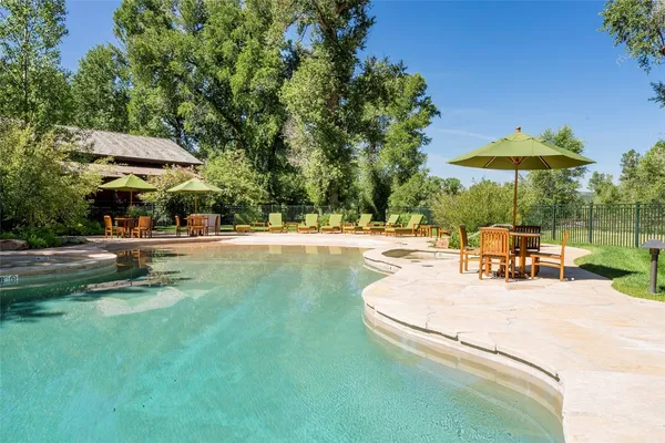 a view of a patio with a table and chairs under an umbrella