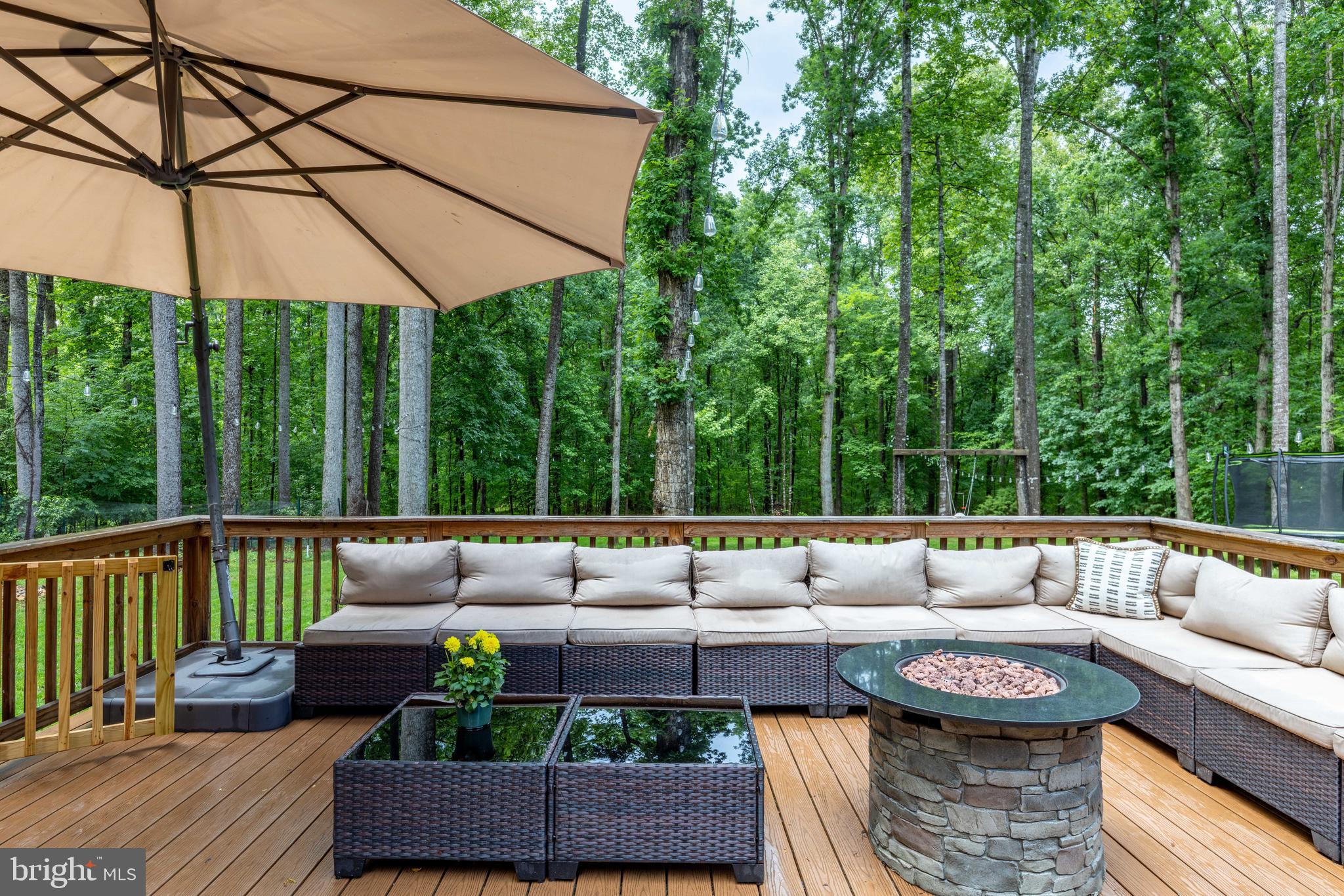 1425 Jacks Shop Road Rochelle, VA 22738 - Photo 49 of 56 a view of a patio with couches table and chairs under an umbrella