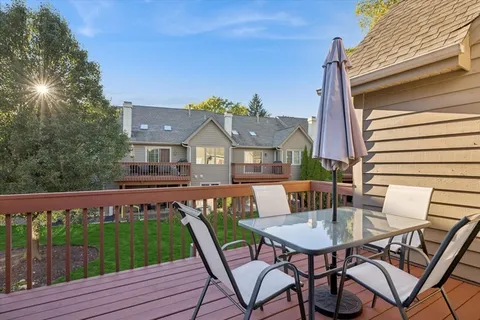 a view of a patio with table and chairs and wooden floor