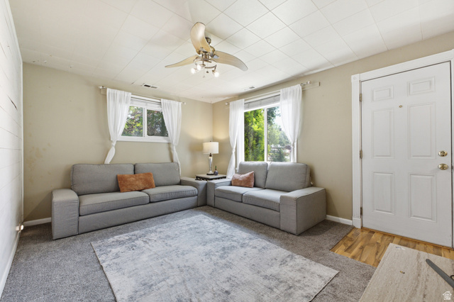 94 West 2000th Street North Clearfield, UT 84015 - Photo 3 of 26 Bright living room featuring multiple windows, ceiling fan, soft carpet, and space for everyday relaxing or entertaining.