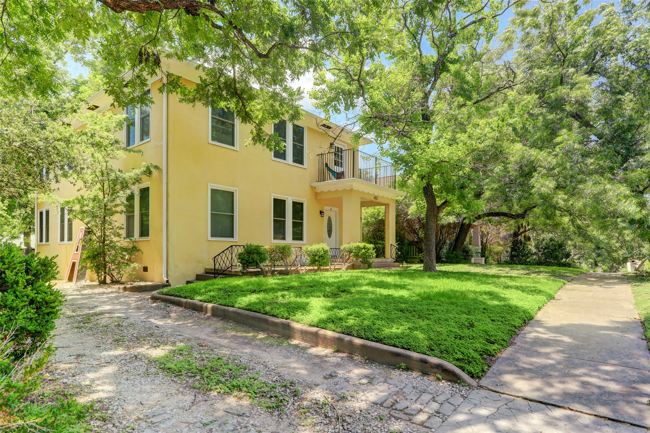 603 Bellevue Place, Unit B Austin, TX 78705 - Photo 19 of 22 a view of a white house next to a yard with big trees
