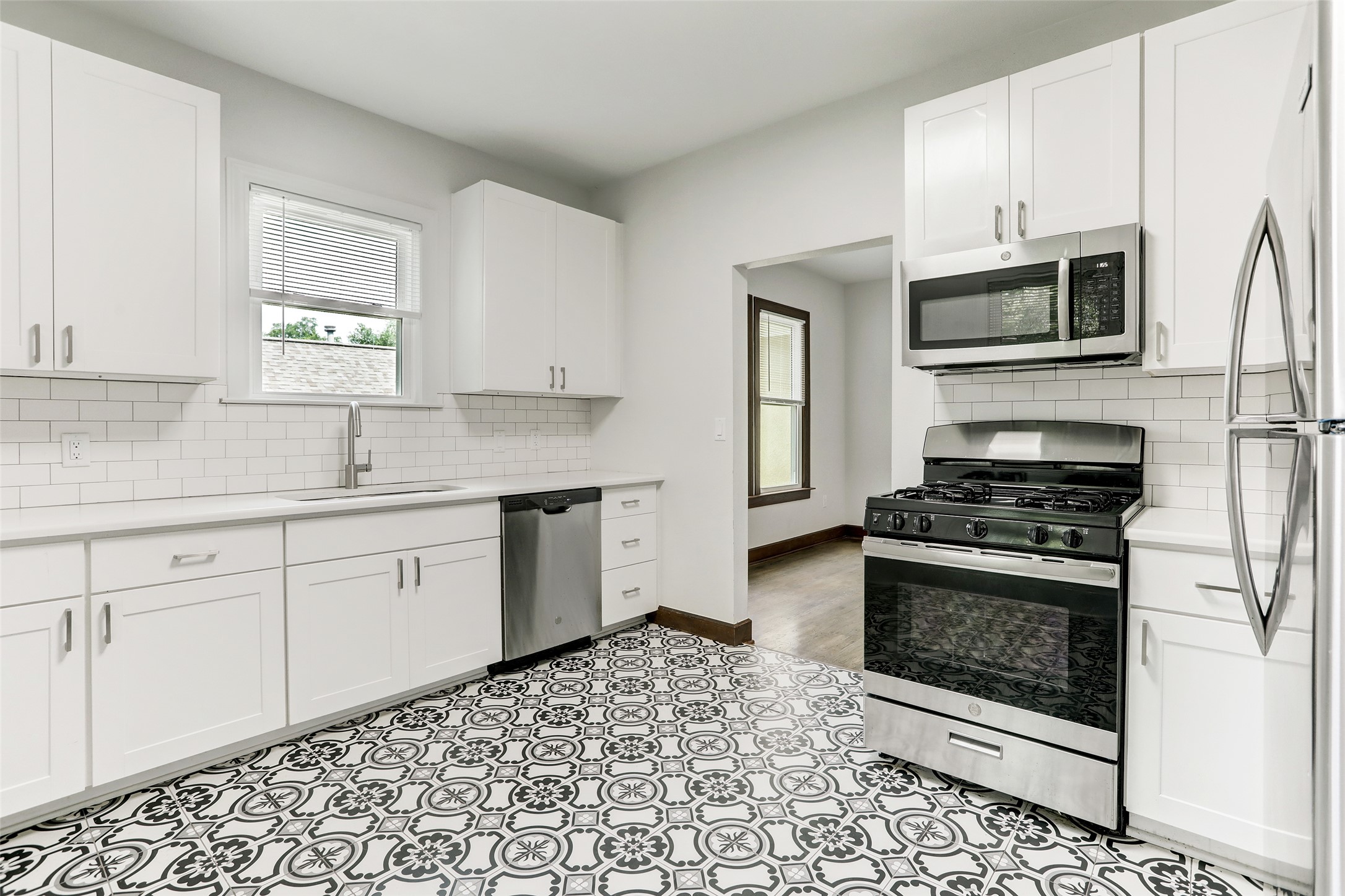 603 Bellevue Place, Unit B Austin, TX 78705 - Photo 7 of 22 a kitchen with stainless steel appliances a stove a microwave sink and cabinets