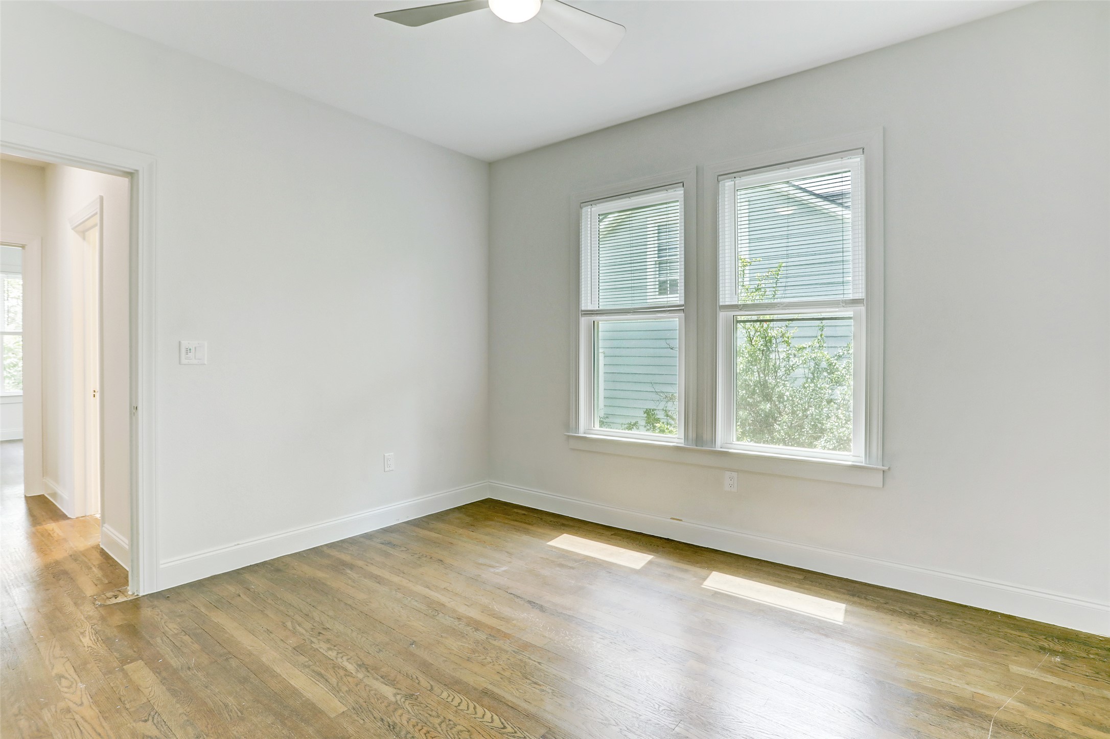 603 Bellevue Place, Unit B Austin, TX 78705 - Photo 10 of 22 an empty room with wooden floor and windows