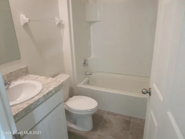 a bathroom with a granite countertop toilet a sink and bathtub