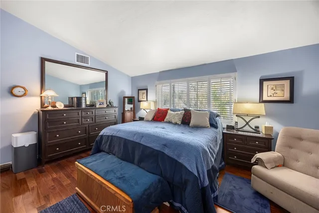 a bedroom with a bed and dresser with mirror