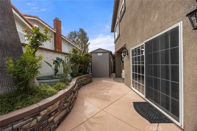 a view of a house with a large window and potted plants