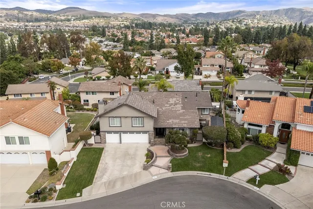 an aerial view of residential houses with outdoor space and parking