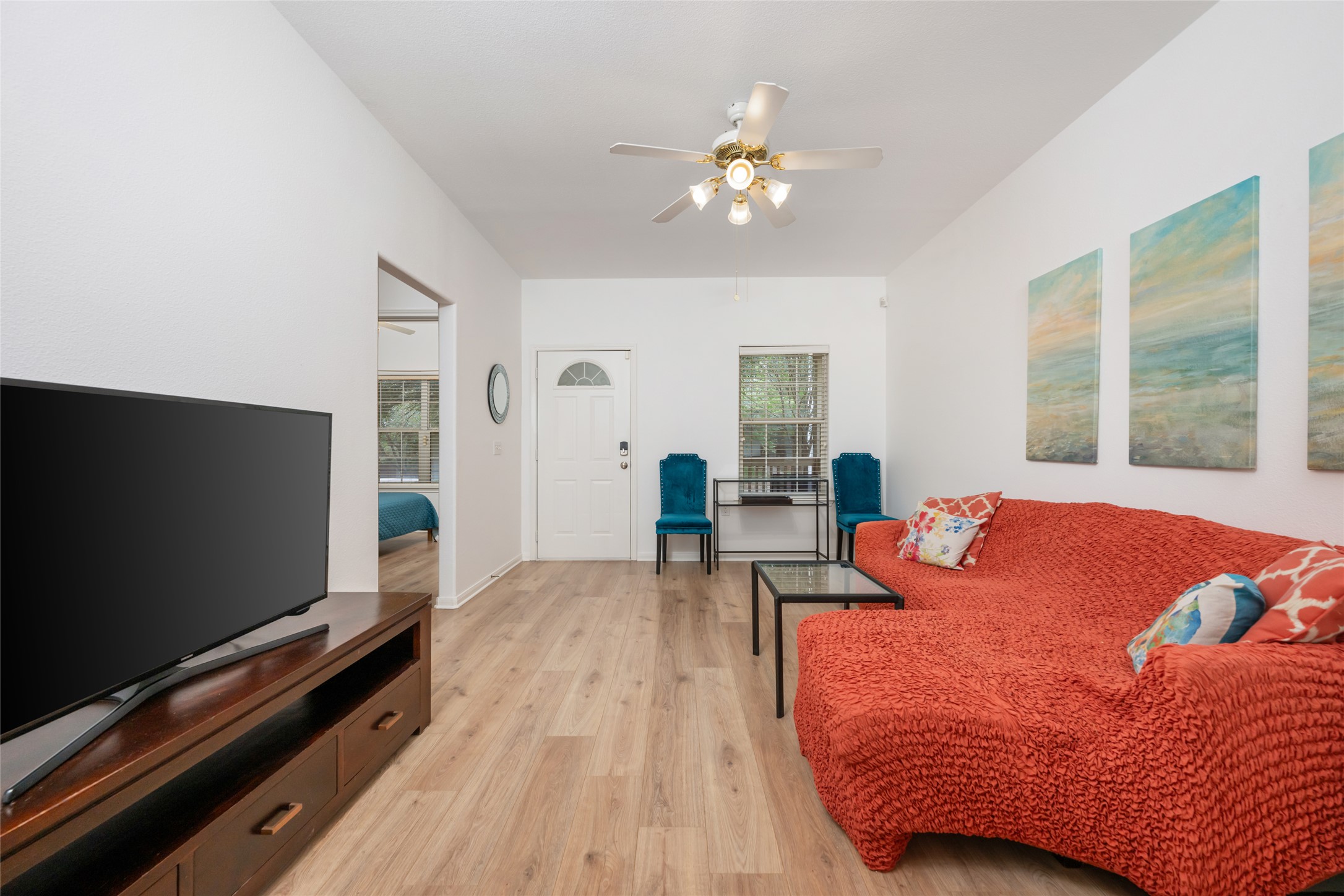 5613 Signal Point Austin, TX 78724 - Photo 6 of 21 Living area featuring light wood-finish flooring, white walls, and a vaulted ceiling with a ceiling fan
