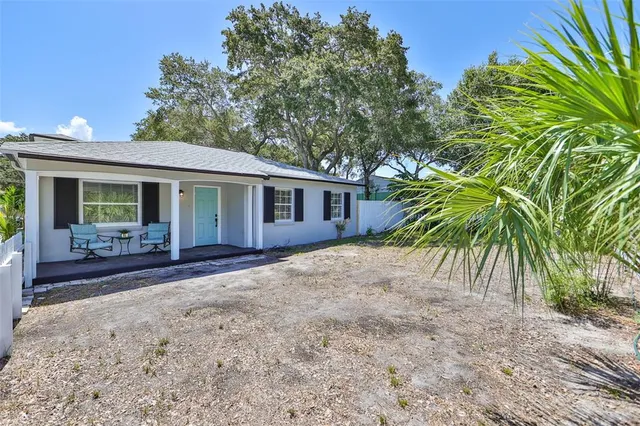 a kitchen with granite countertop a stove a sink and a refrigerator