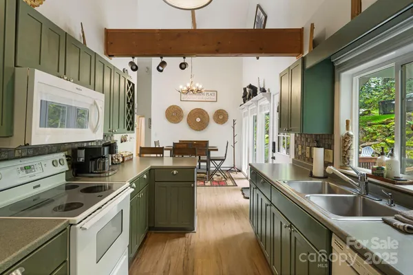 a kitchen that has a sink a stove and a wooden floor