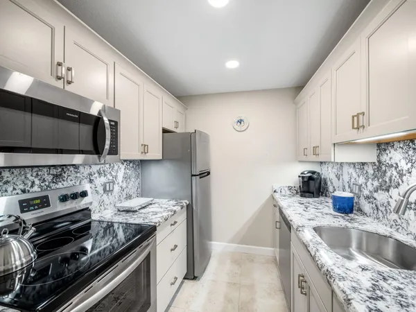 a kitchen with a stove a sink and a microwave