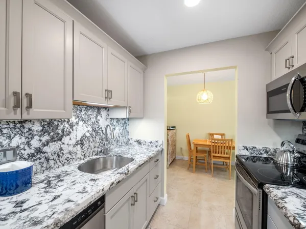 a kitchen with stainless steel appliances granite countertop a sink stove and cabinets
