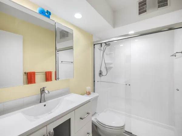 a bathroom with a sink a toilet and shower