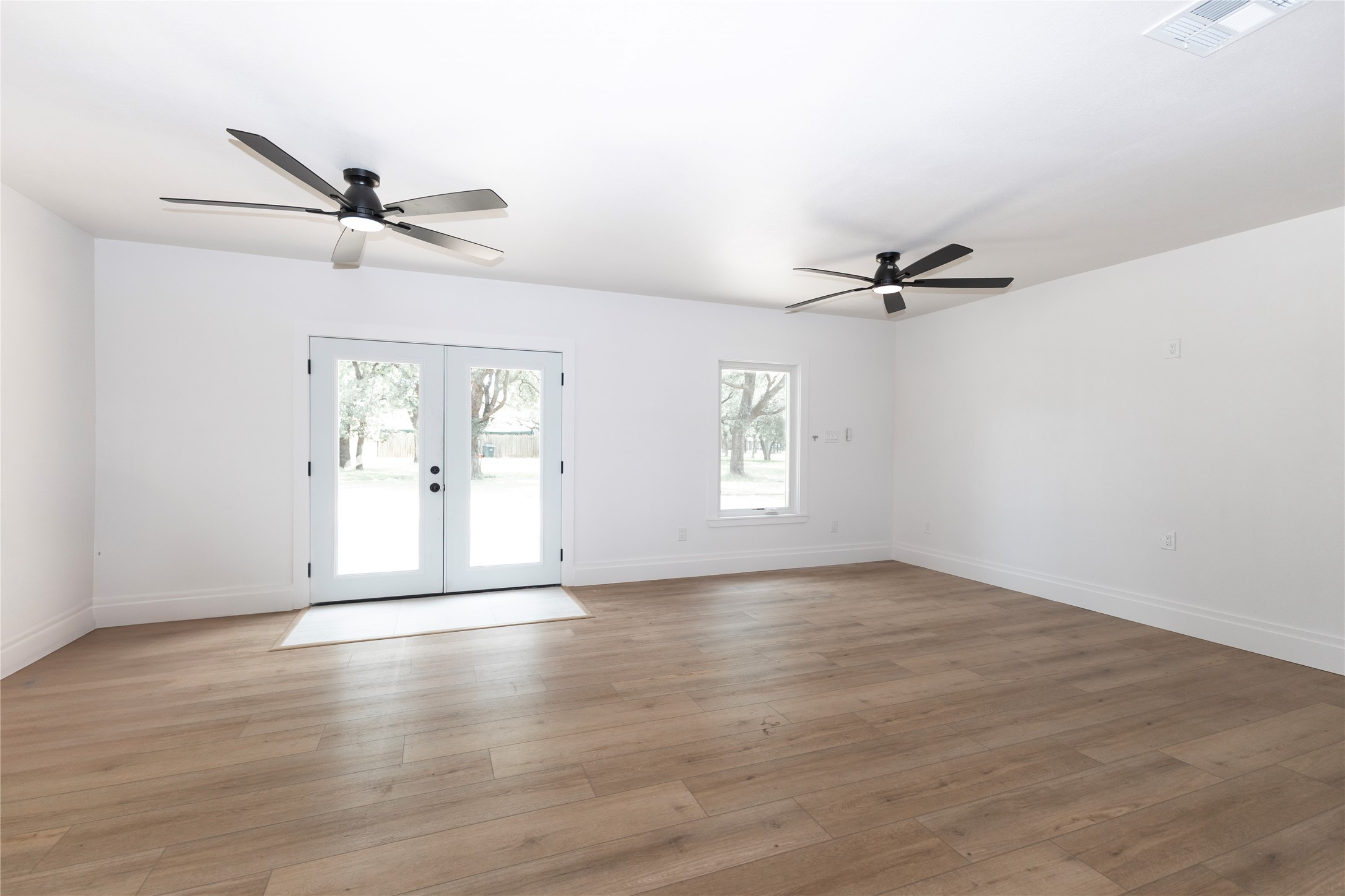 205 Bello Circle Georgetown, TX 78628 - Photo 11 of 36 Hardwood flooring extends throughout this generous room with French doors to the outside.