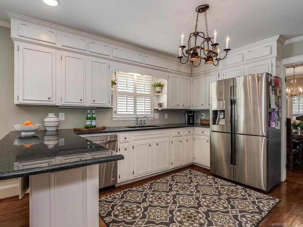 3108 Wickersham Road Charlotte, NC 28211 - Photo 6 of 34 a kitchen with stainless steel appliances granite countertop a refrigerator a sink dishwasher a stove a dining table and chairs with wooden floor