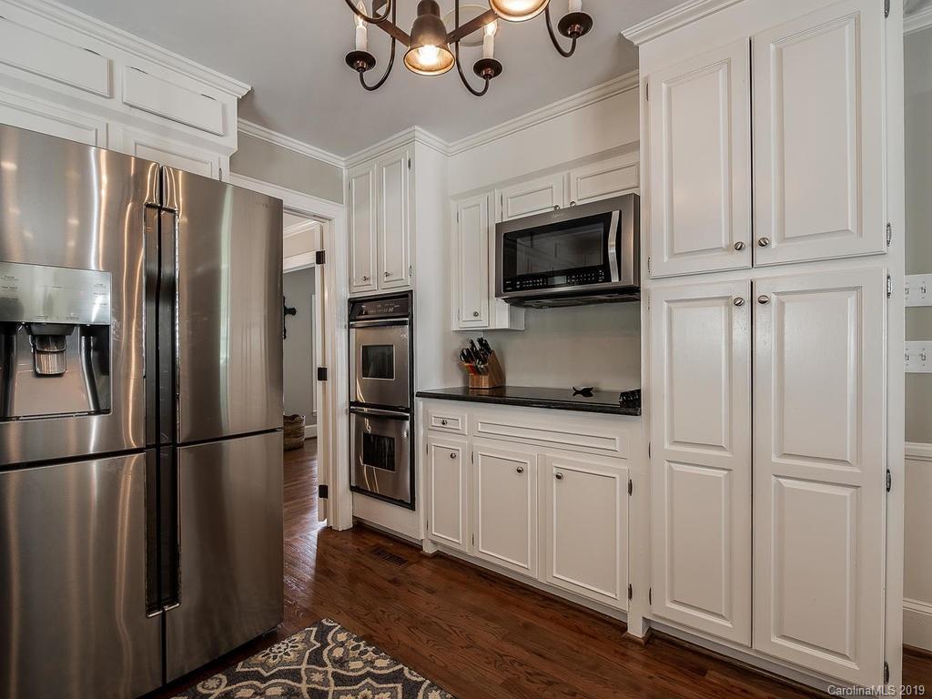3108 Wickersham Road Charlotte, NC 28211 - Photo 7 of 34 a kitchen with stainless steel appliances granite countertop a refrigerator a microwave a sink and white cabinets