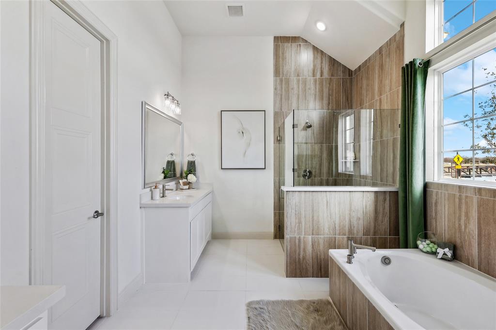 1604 Casting Ridge Mesquite, TX 75181 - Photo 19 of 38 Bathroom featuring a dual vanity with undermount sinks, a walk-in shower with glass enclosure, a built-in soaking tub, wood-look tiled walls, and large windows