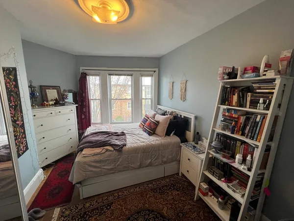 a bedroom with a bed and a book shelf