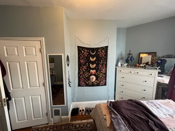 a bedroom with a bed and wooden floor