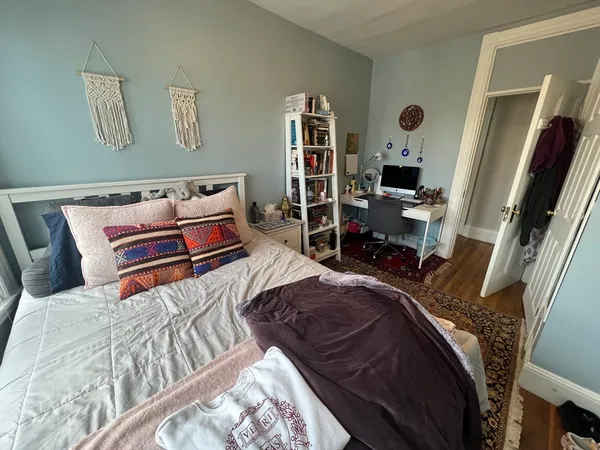 a bedroom with a bed and a large mirror on the dresser