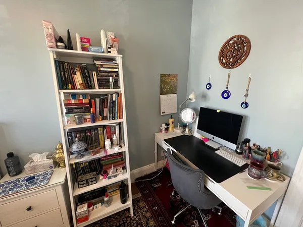 a view of a workspace with furniture and a book shelf