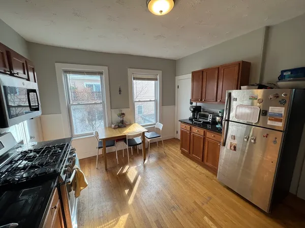 a kitchen with sink a refrigerator and wooden floor