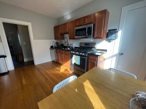 a kitchen with stainless steel appliances granite countertop a stove a sink a microwave a refrigerator a cabinets and furniture