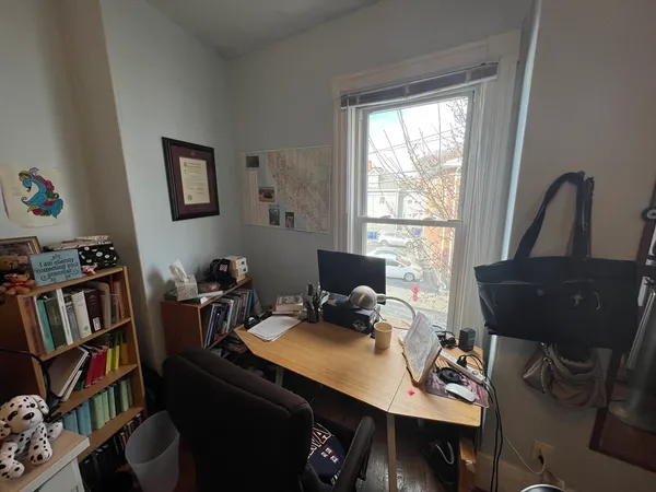 a view of a workspace with furniture and a window