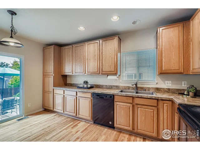 a kitchen with a sink wooden cabinets and white appliances