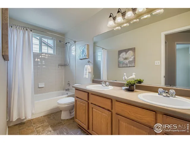 a bathroom with a granite countertop sink toilet mirror and bathtub